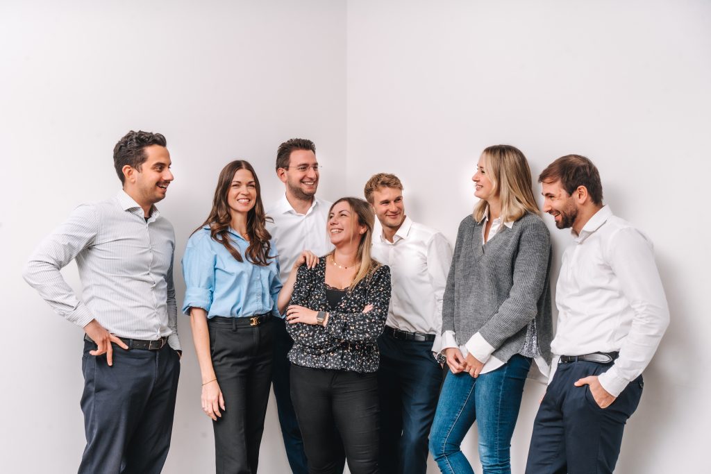 Das Team der Kanzlei mgp steht gemeinsam vor einer weißen Wand