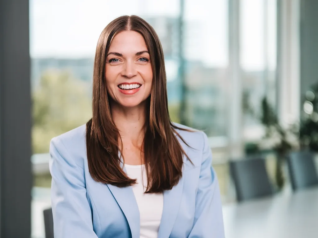 Livia Merla Porträt. Sie hat einen hellblauen Anzug an und schaut sehr freundlich.