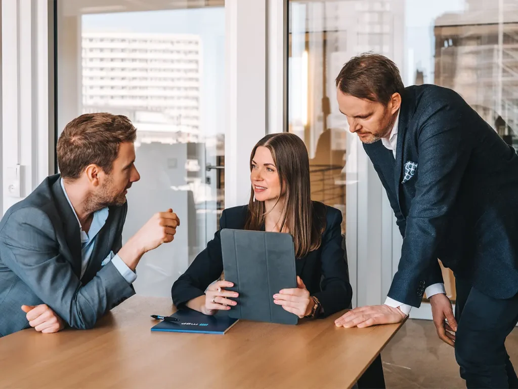 Arbeitsrecht für Geschäftsführer und Führungskräfte. Zwei Männer und eine Frau (die Partner der Kanzlei mgp) sitzen am Tisch und besprechen sich. 
